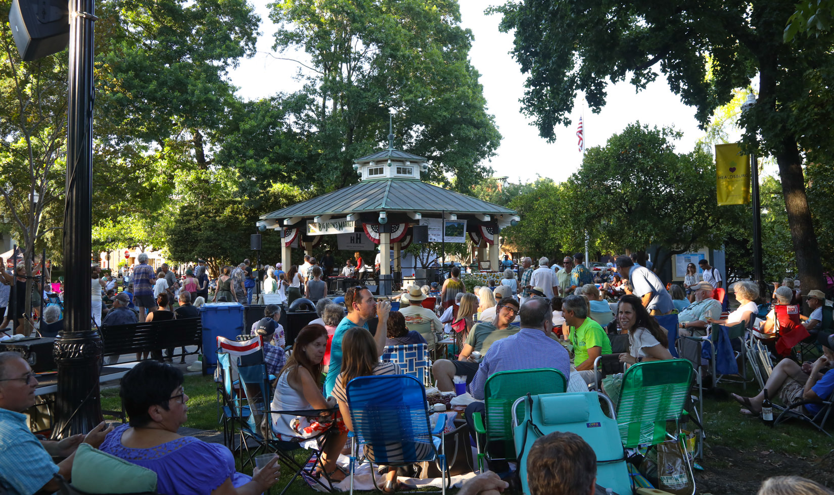 music festival in the healdsburg plaza where a lot of people are sitting and drinking. 