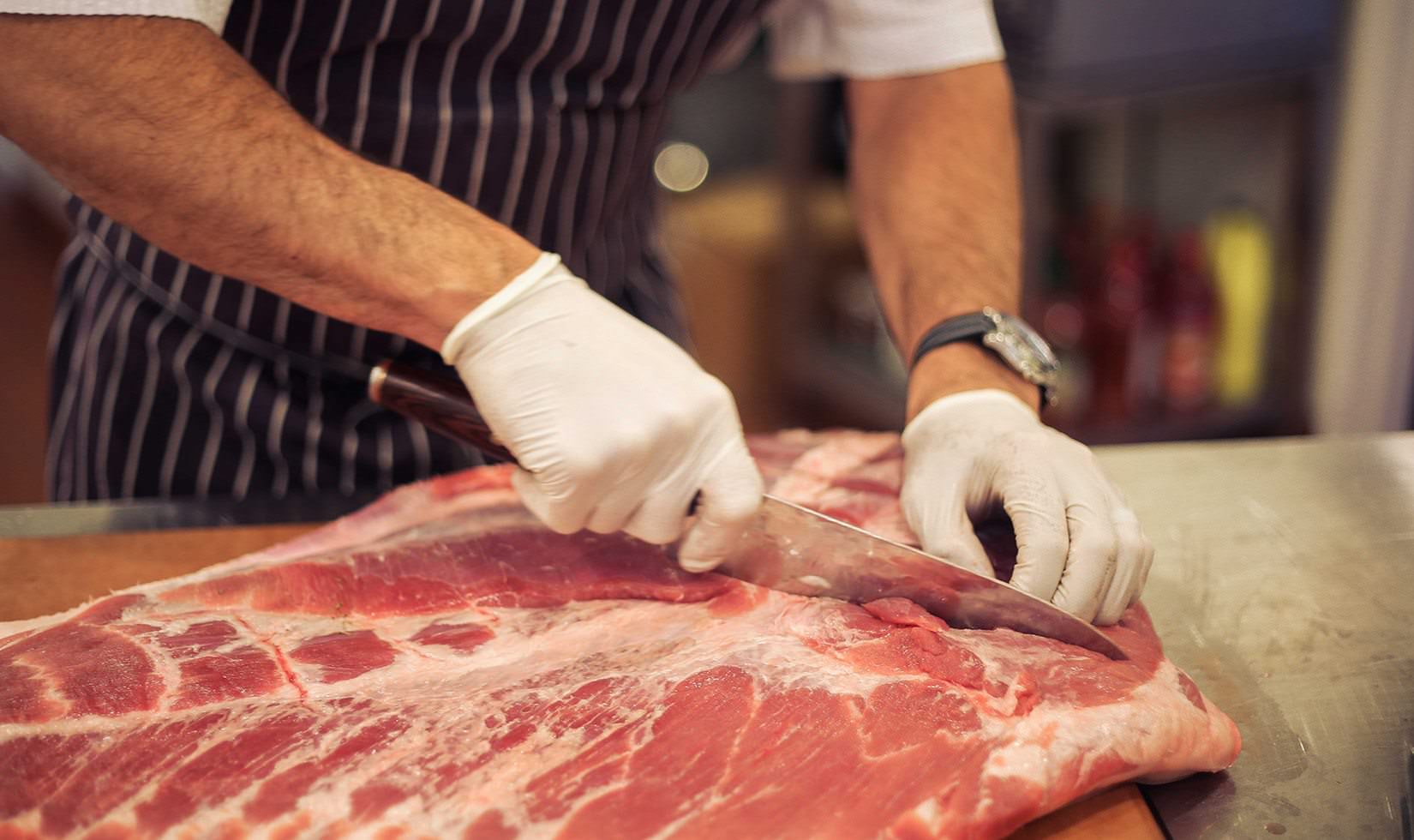 Herb Roasted Pork Belly Porchetta Recipe chef slicing the meat