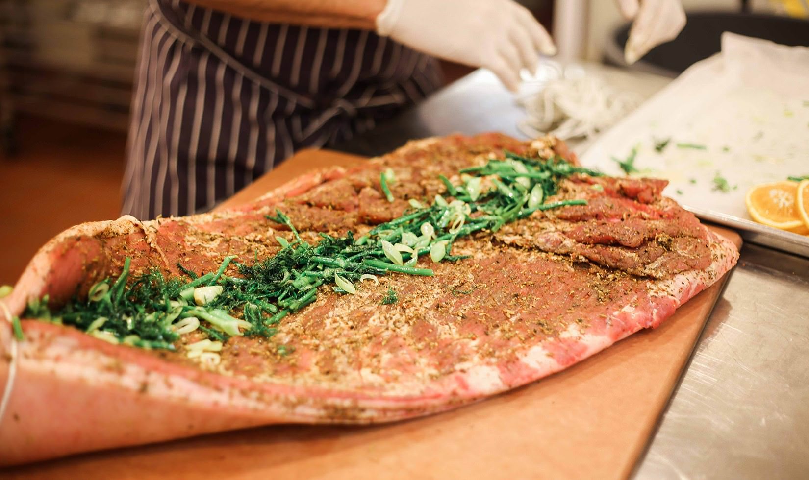 Herb Roasted Pork Belly Porchetta Recipe rolling up the pork belly and putting the herbs and spices inside
