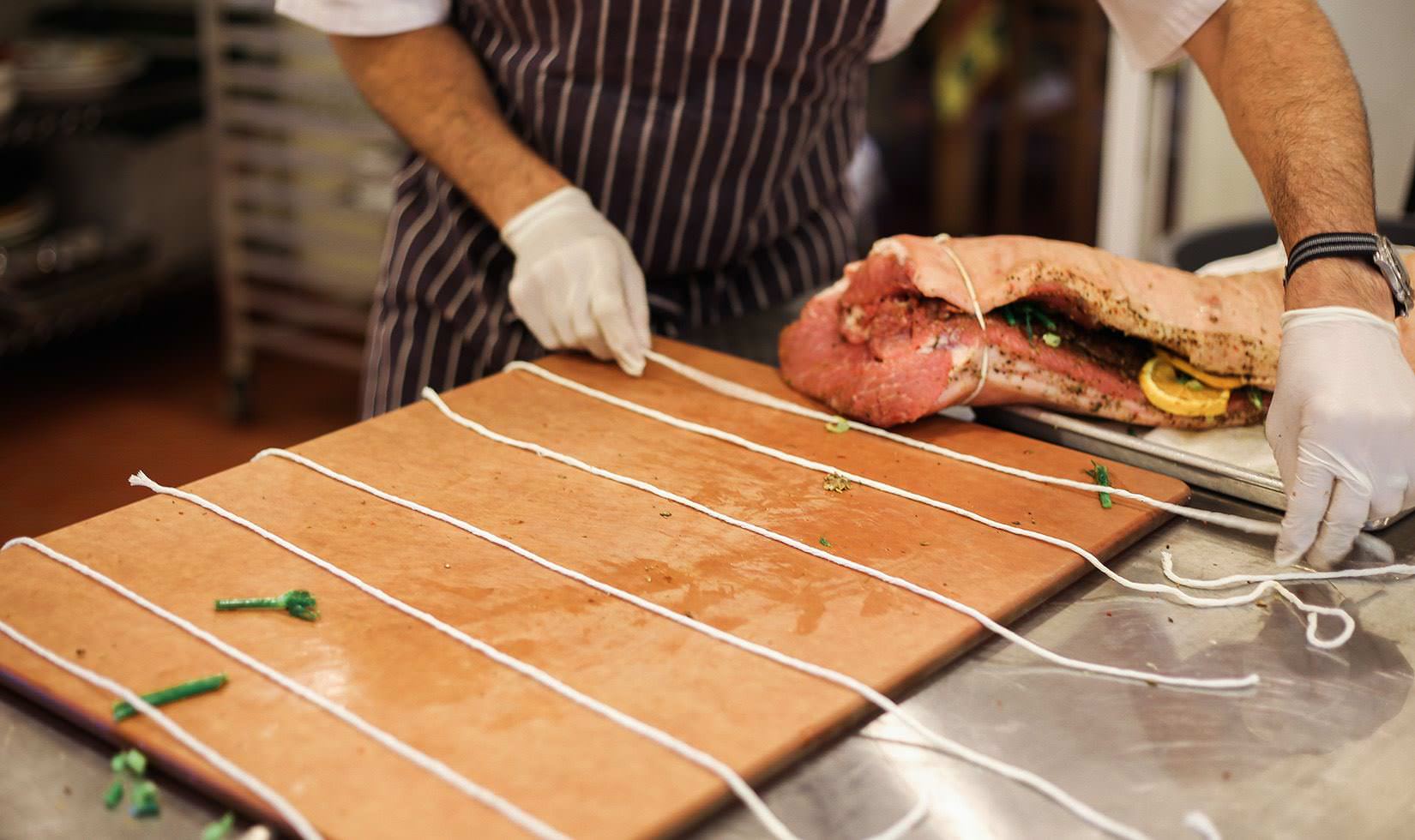 Herb Roasted Pork Belly Porchetta Recipe closing both ends for pork belly ready to be roasted