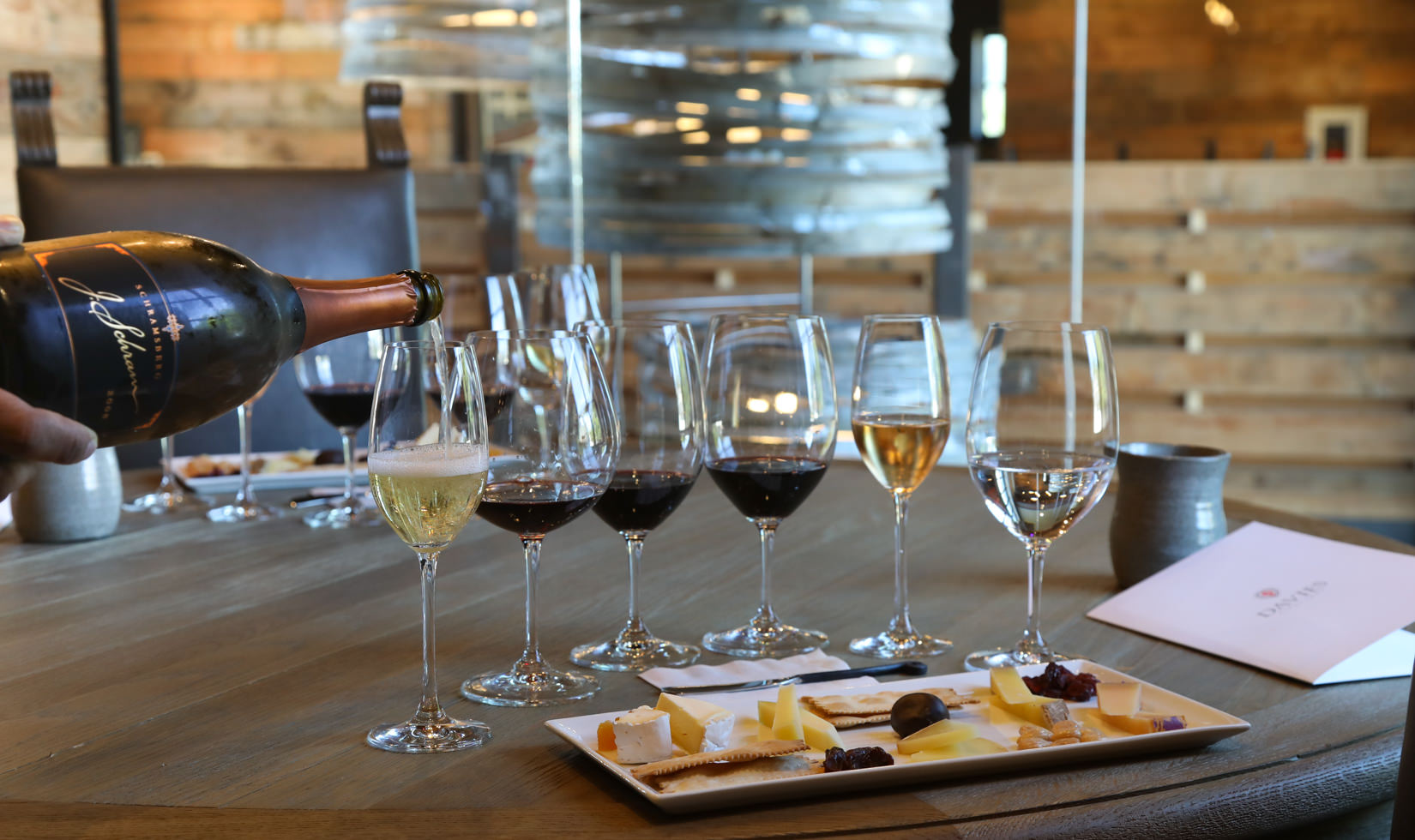 wine poured out to wine glasses with cheese pairing