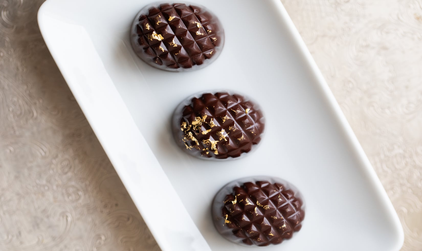 dark chocolate ganache truffles arranged on white plate