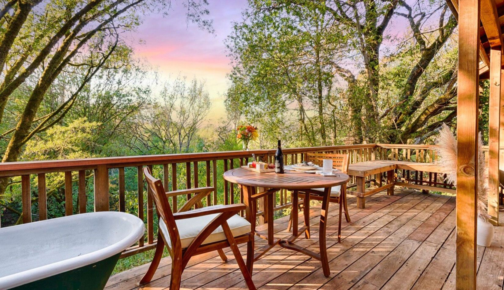 Cottage deck in redwoods with bathtub and bistro table with wine