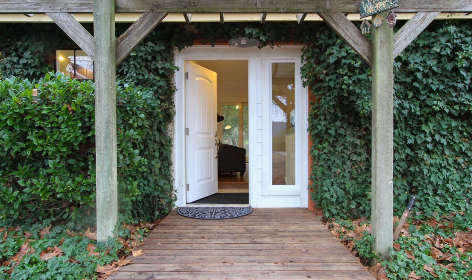 Front door of wine country cottage with ivy on façade 
