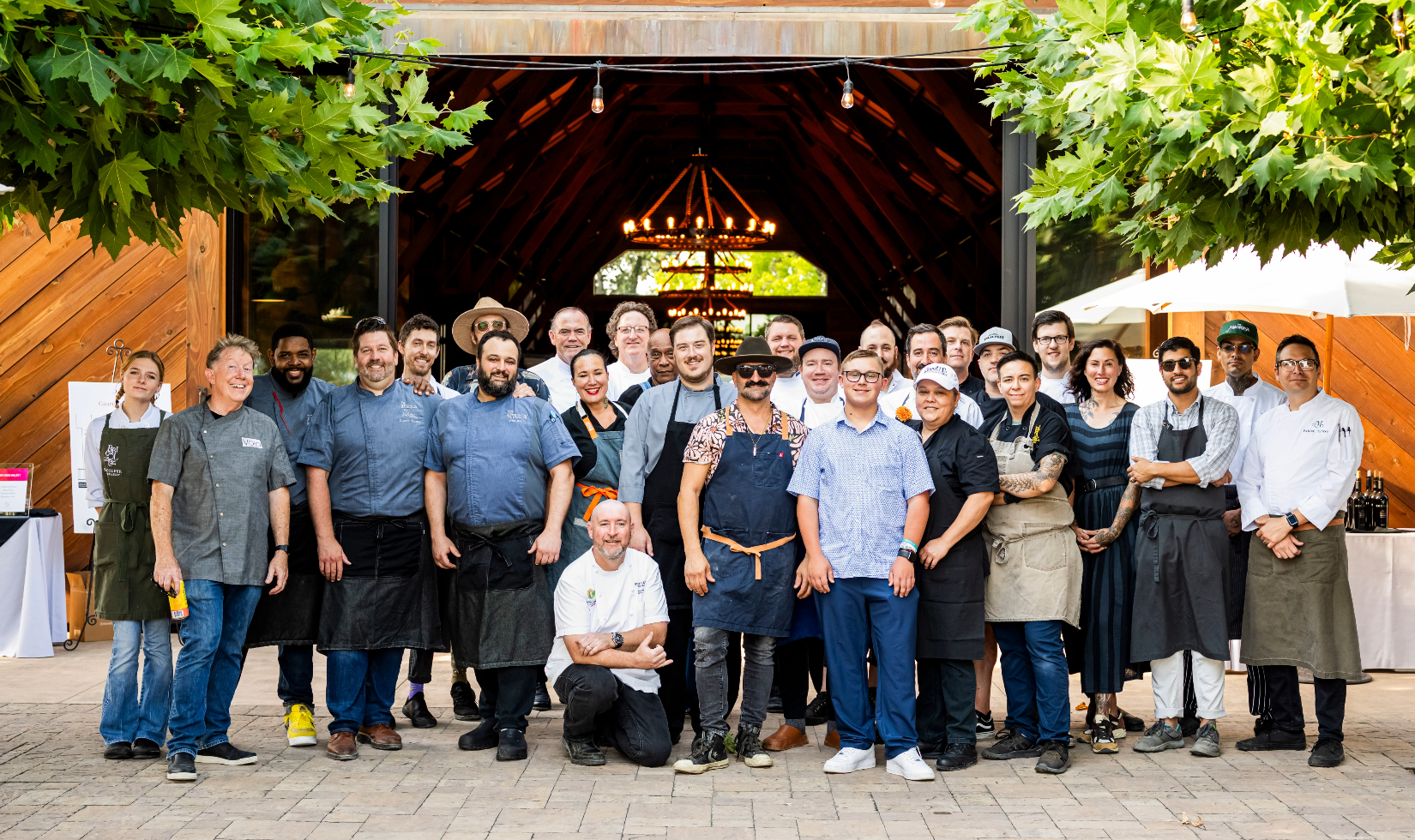 Wine Companies that Donate to Charity 3 Winery team dressed in work clothes and uniforms standing on a terrace outside of the winery dining room.