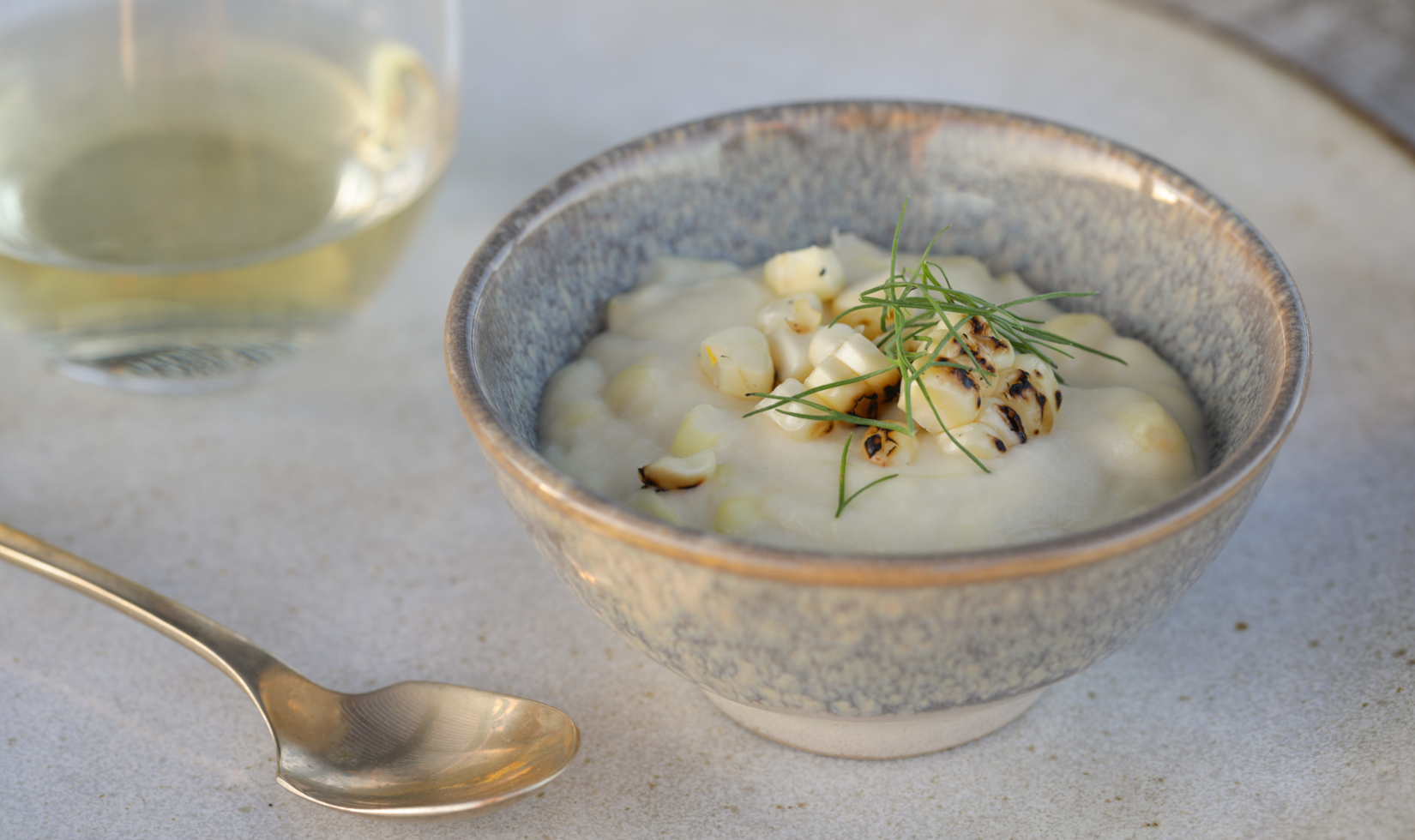 Thanksgiving Dinner Ideas 2 close up corn pudding in a grey bowl with spoon and jordan chardonnay wine