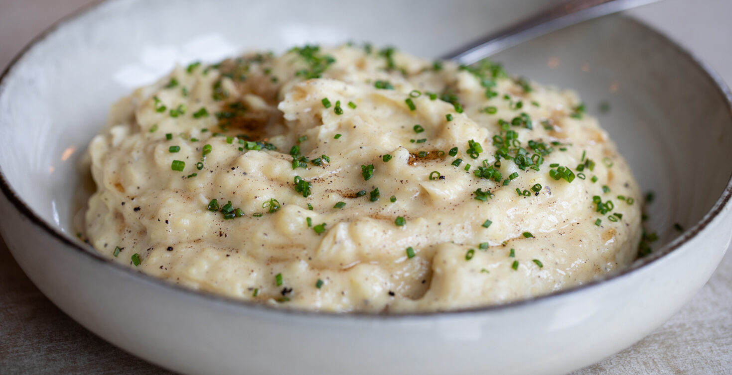 Close image of brown butter mashed potatoes in white bowl