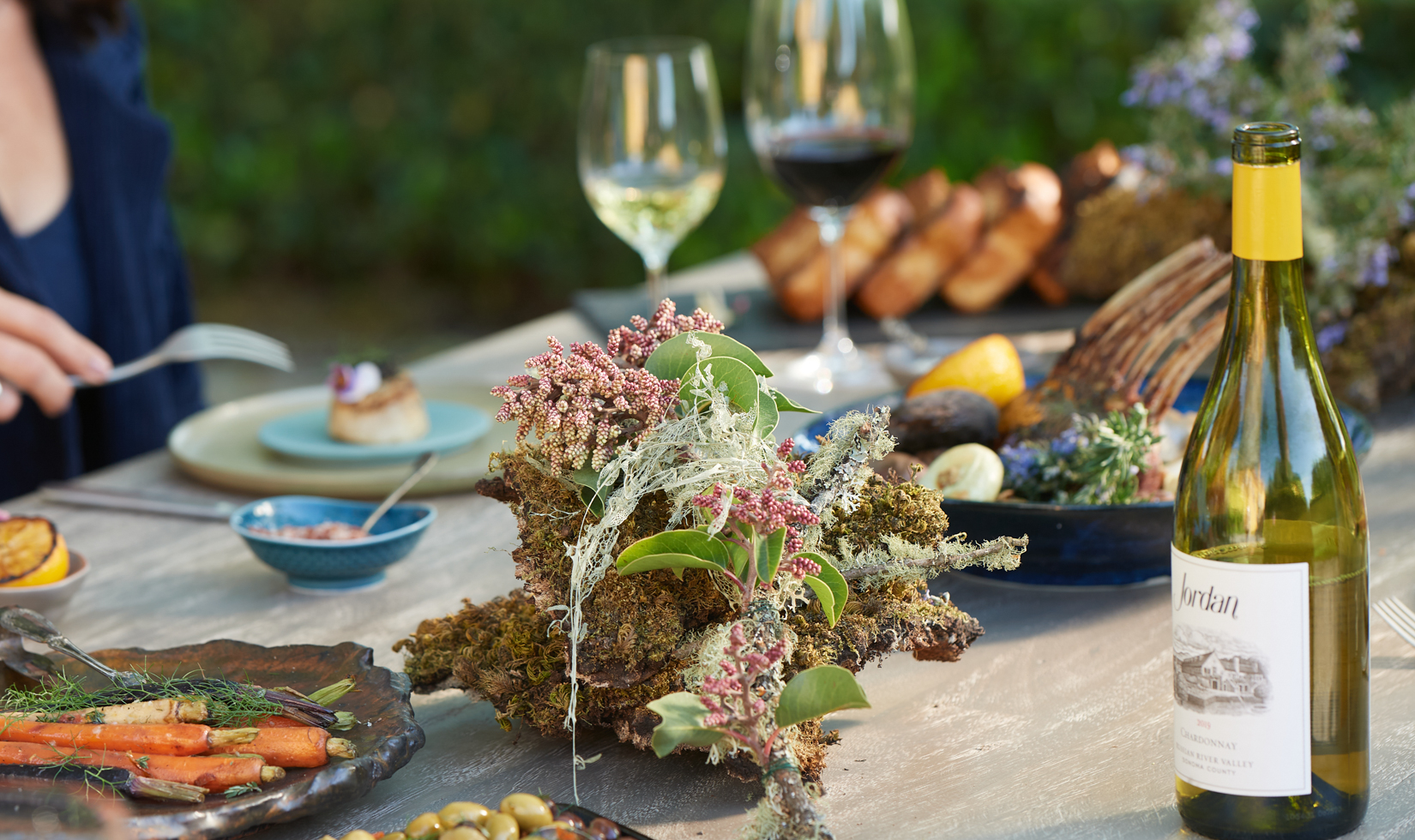 branch centerpiece with chardonnay and wine glasses on table