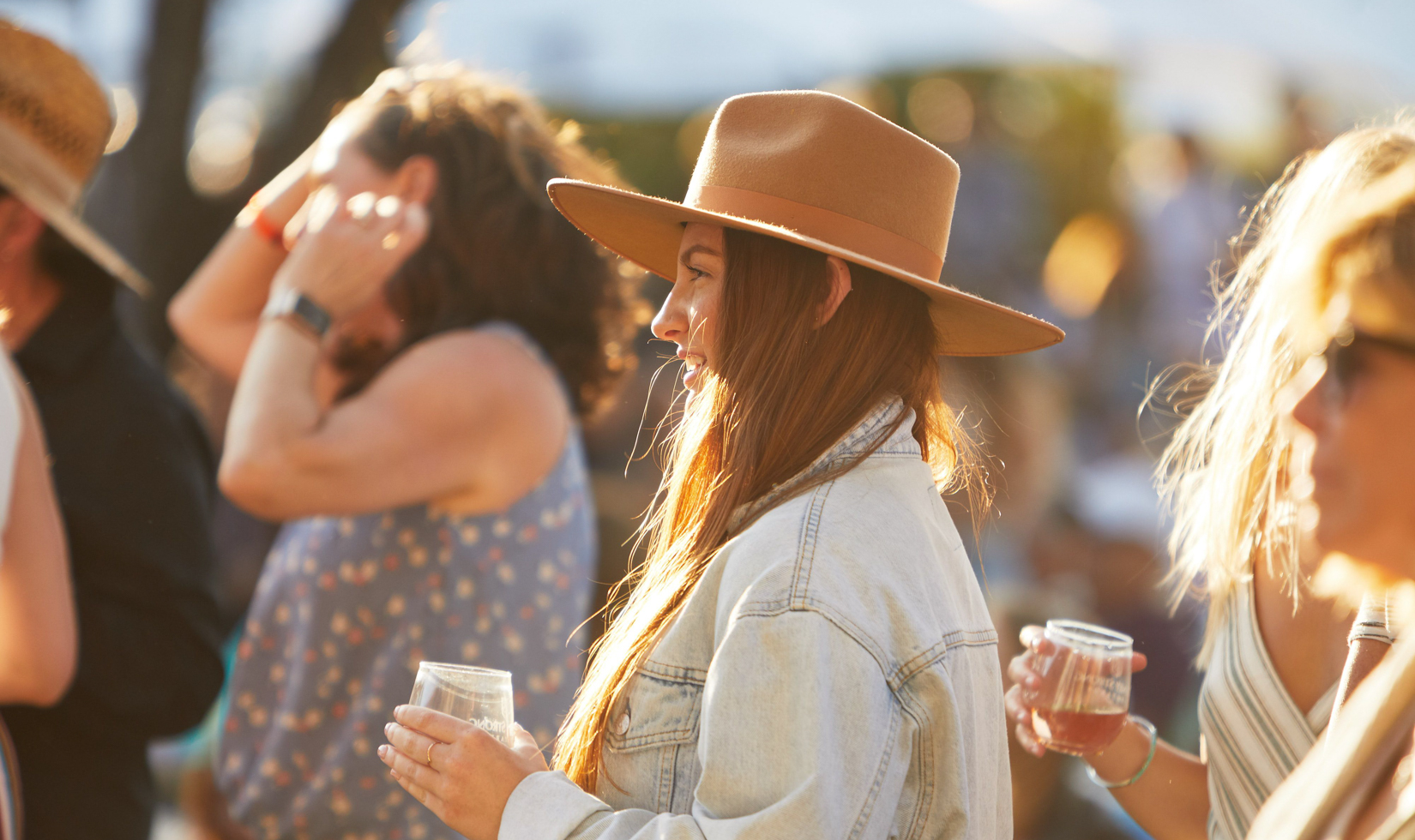 girl holding glass of wine at an outdoor music concert