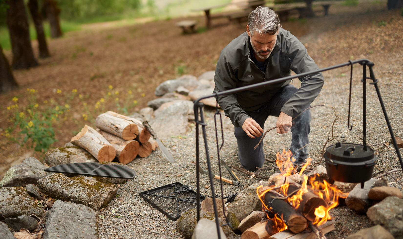 Best Fuels for BBQ and Grilling a man setting up a fire for barbecue and heating some water