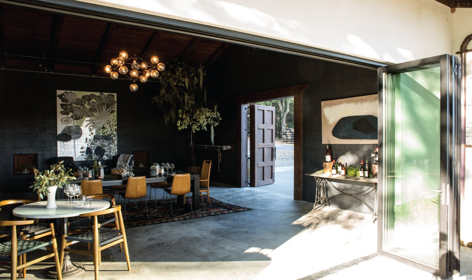 Best Wineries in Healdsburg Reeve tasting room with bohemian furniture and concrete floors with door open to terrace.
