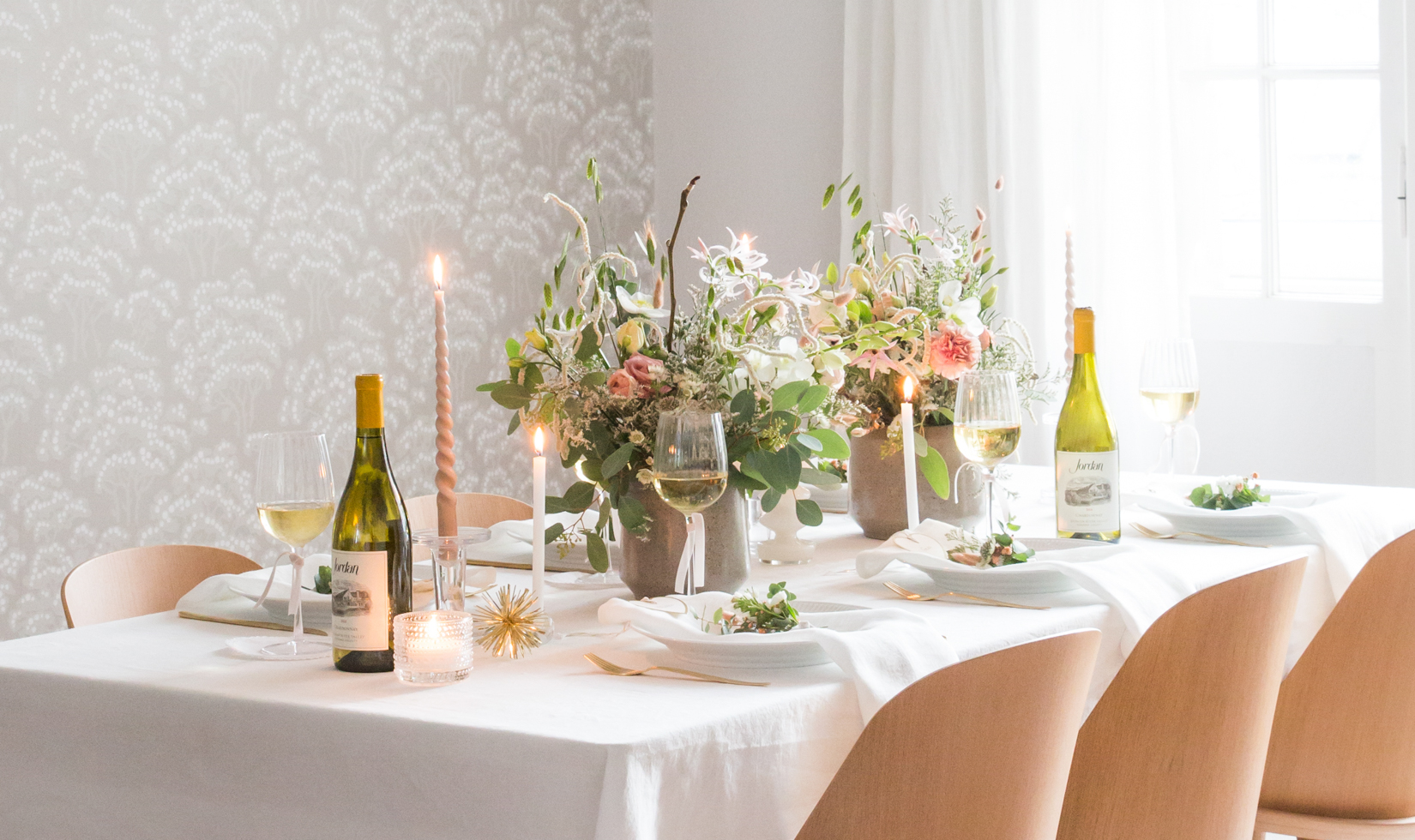 table decoration for birthdays with wine, plates, flower centerpiece