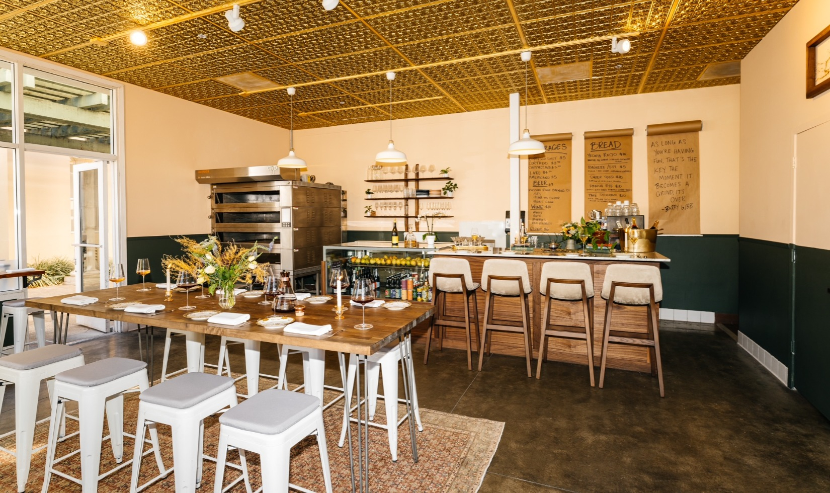 Interior of Troubadour restaurant with counter seating and tables set for dinner.