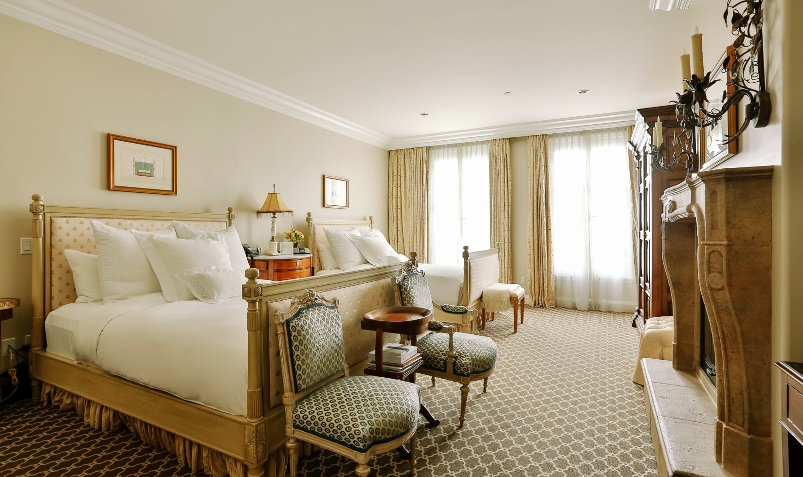Luxurious bedroom with classic decor and a fireplace.