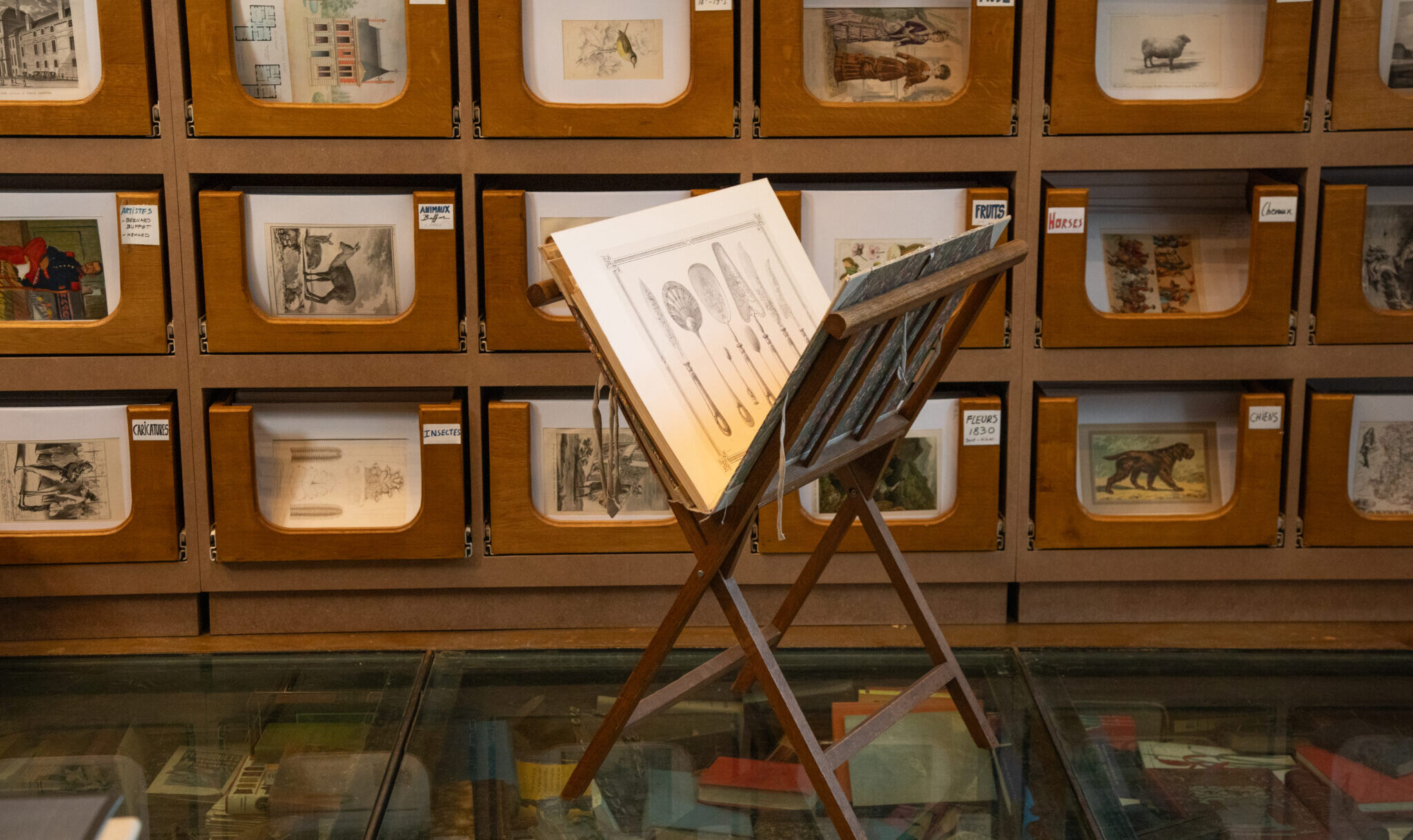 art prints organized along wooden shelves