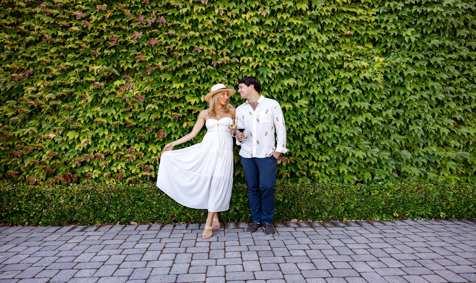 a couple posting for picture while holding a wine glass