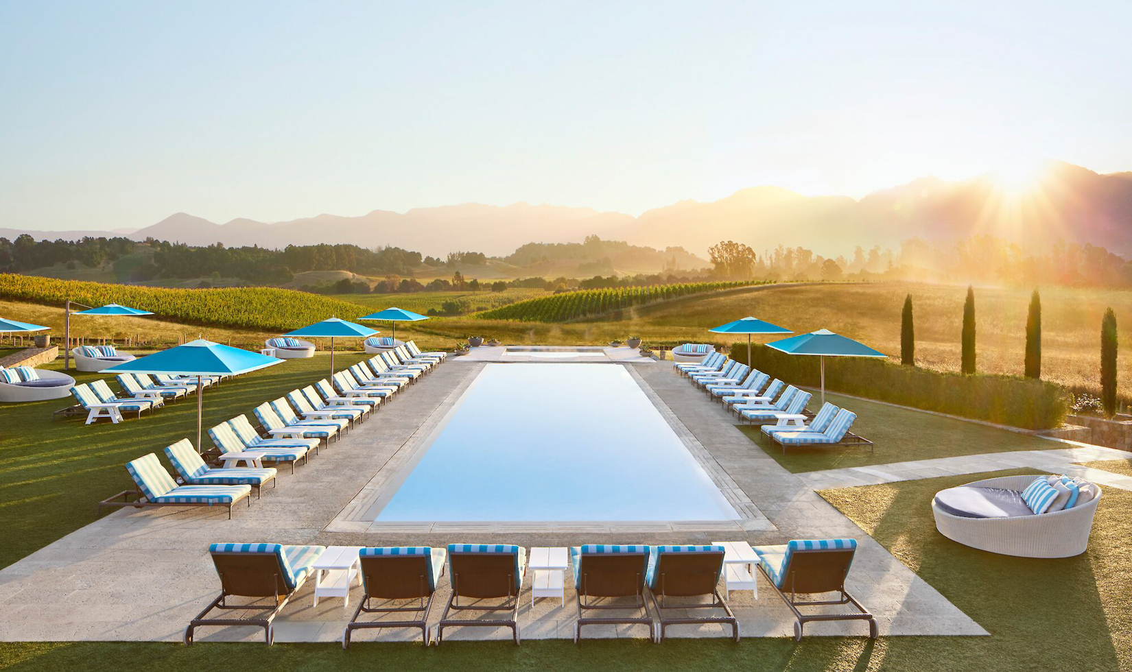 outdoor pool at sunset overlooking mountains and vineyards